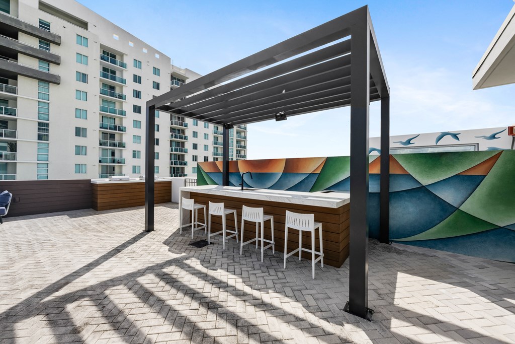a patio with a bar and a mural on the side of a building