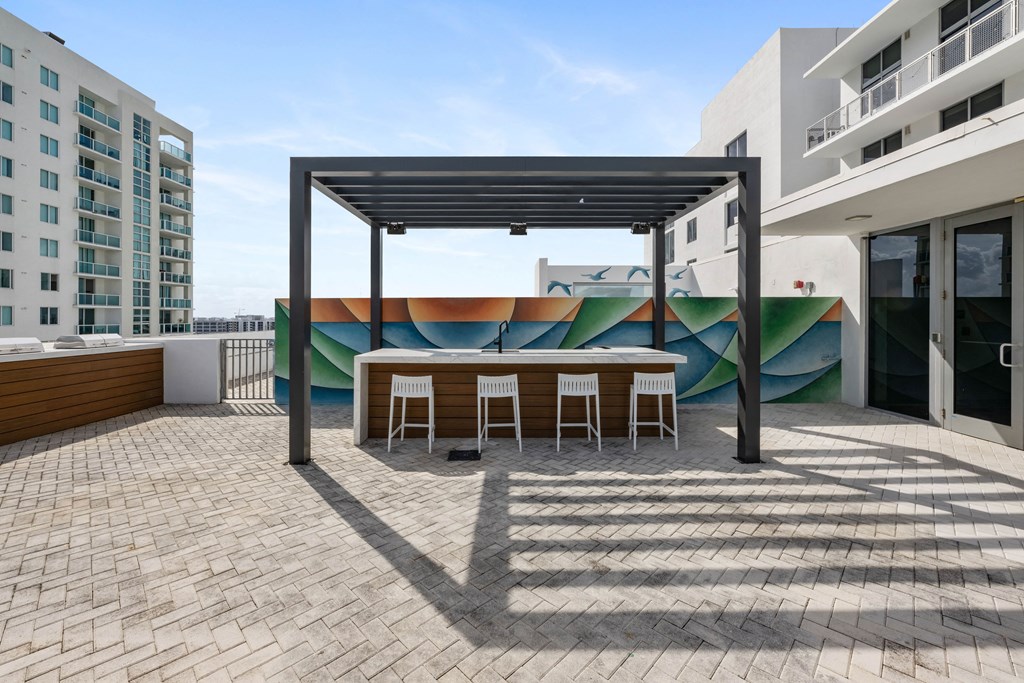 a patio with a table and chairs and a mural on the wall