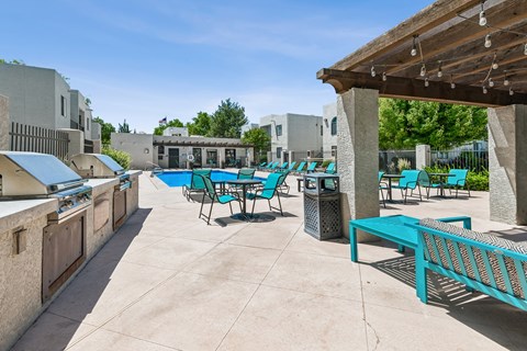 A sunny day at the outdoor pool area with blue chairs and tables.