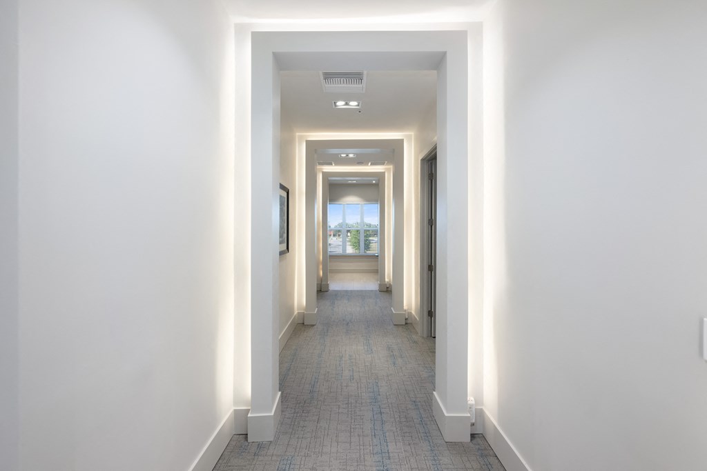 interior long corridor with white walls and grey tile floors