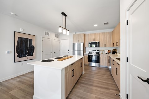 A modern kitchen with wooden cabinets and a white island.