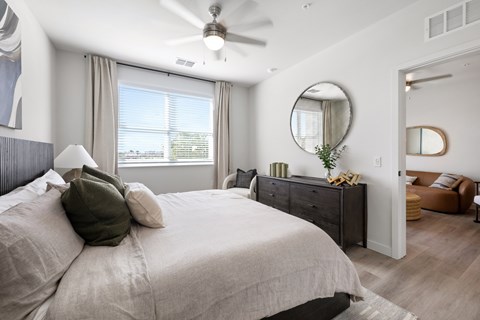 A bedroom with a large bed and a ceiling fan.