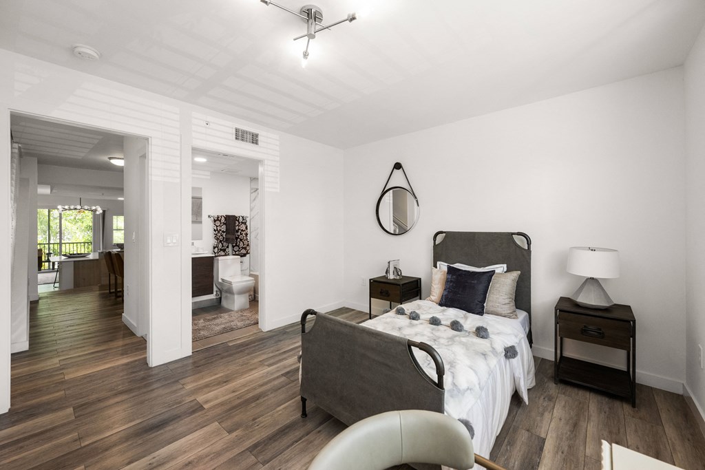 a bedroom with a bed and a chair and a bathroom