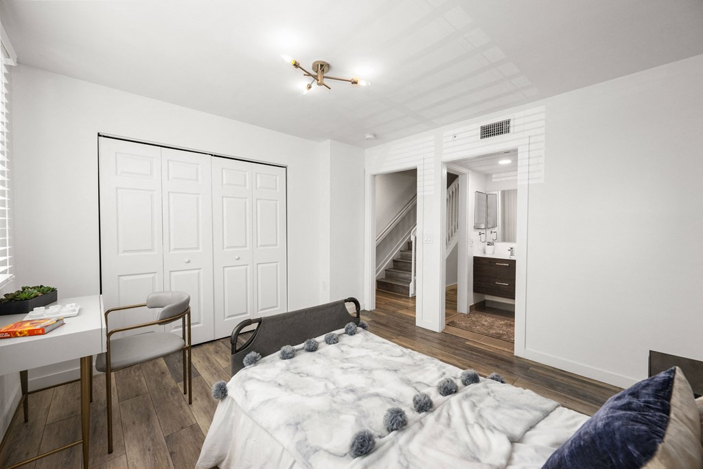 a bedroom with a large bed and a desk with a chair
