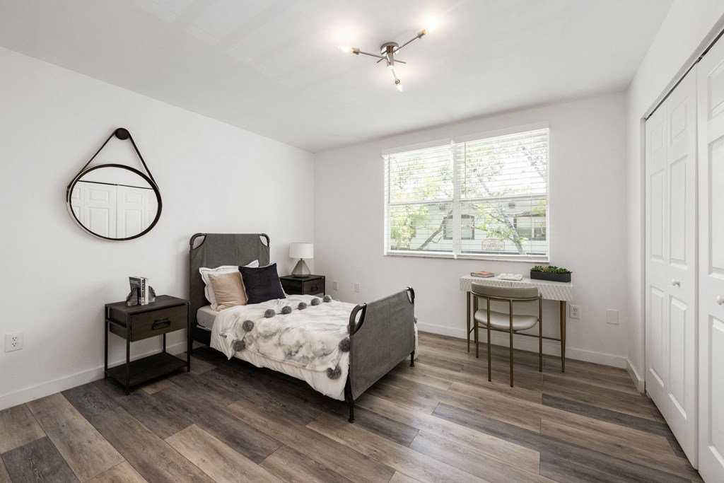 a bedroom with a bed and a desk with a chair