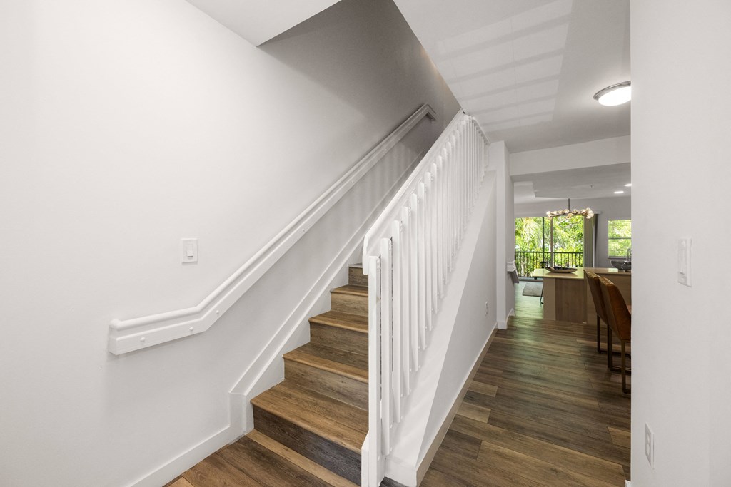 a view of a staircase in a home with white walls and wood floors