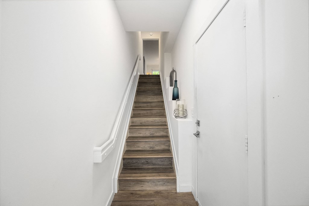 a staircase with wooden floors and white walls in a home