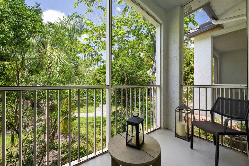 a balcony with a view of a yard and trees