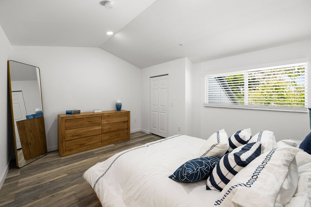 a bedroom with a bed and a dresser and a window
