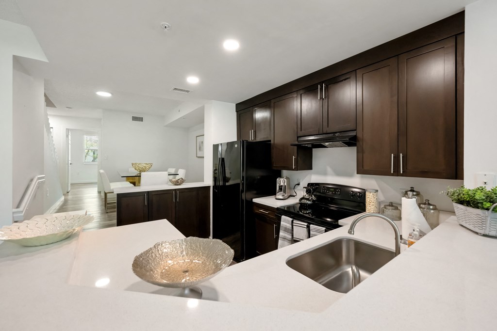 a large kitchen with a white counter top and a sink