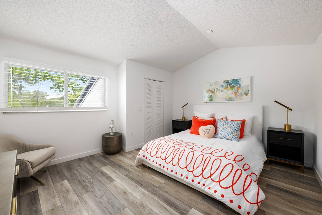 a bedroom with a bed and a couch and a window