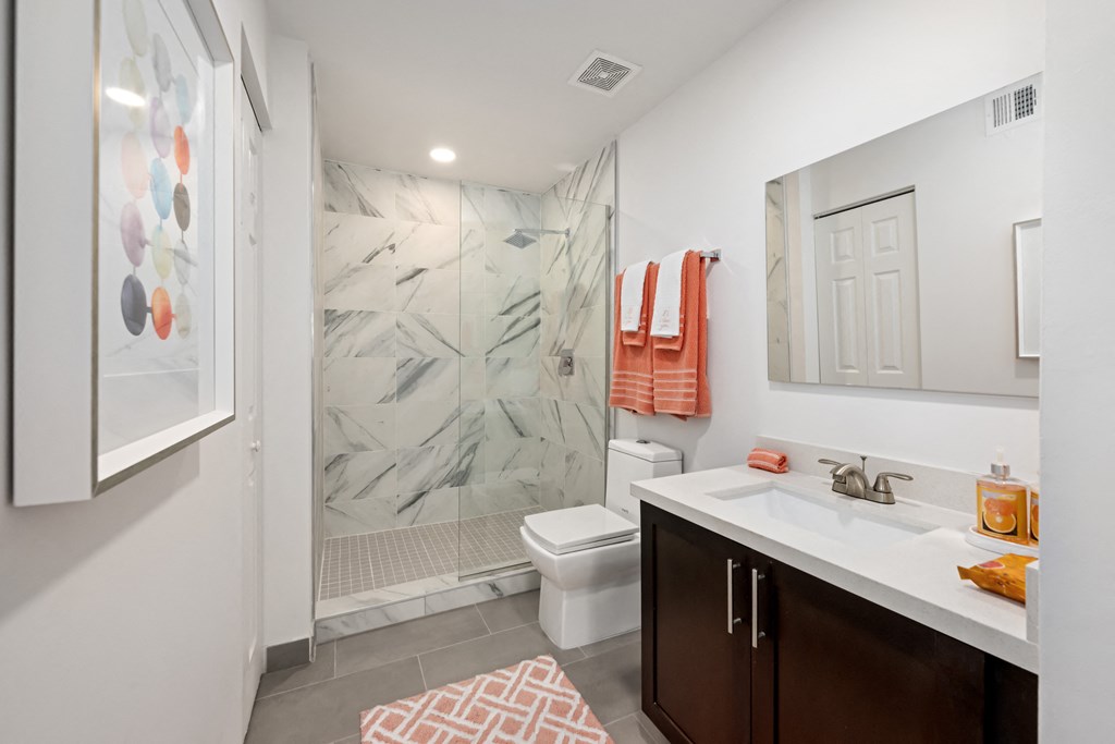 a bathroom with a shower and a sink and a toilet