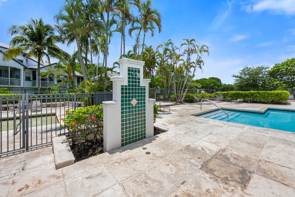 the pool is next to a house with palm trees