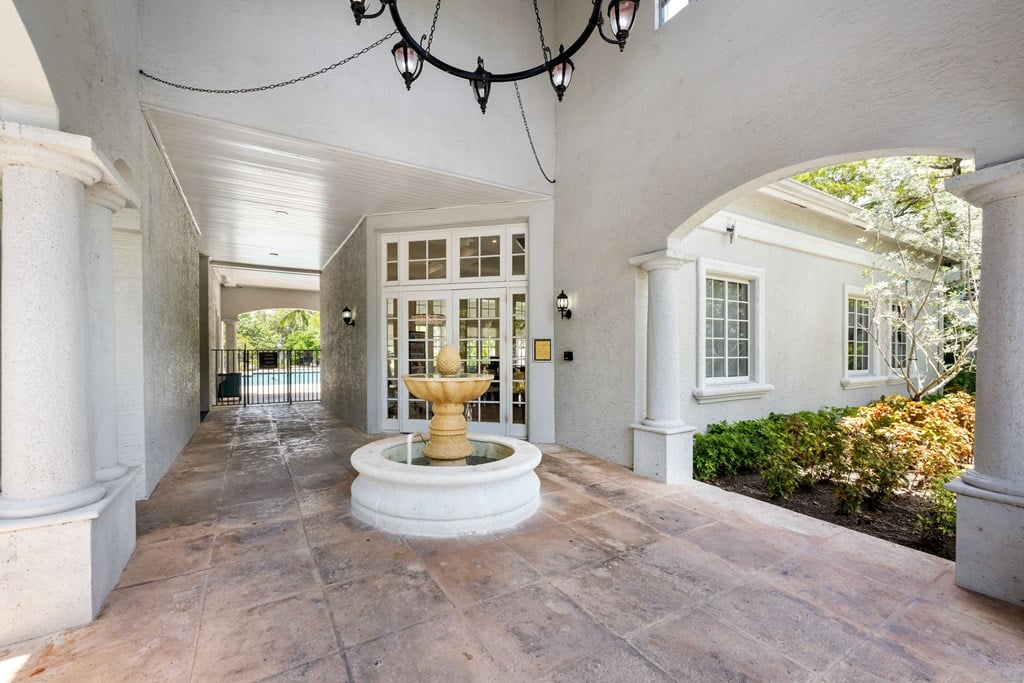 a courtyard with a fountain in the middle of a white house