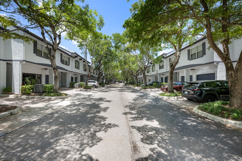 a tree lined street with houses on either side of it