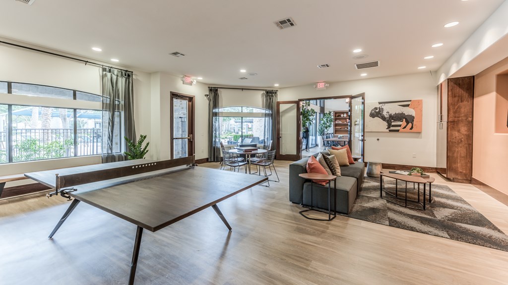 A ping pong table is in the middle of a living room.