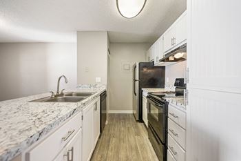 an expansive kitchen with granite counter tops and black appliances