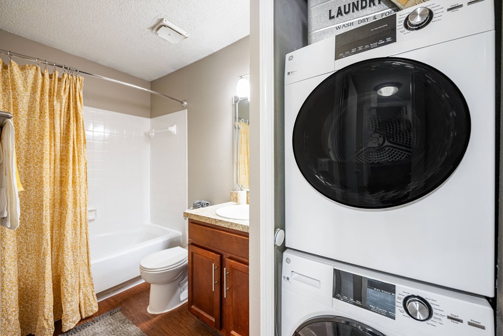 a washer and dryer in a bathroom next to a toilet and a sink