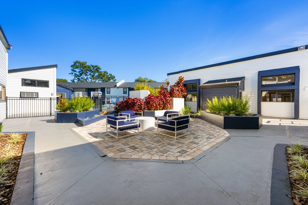 a patio with chairs and tables in front of a building