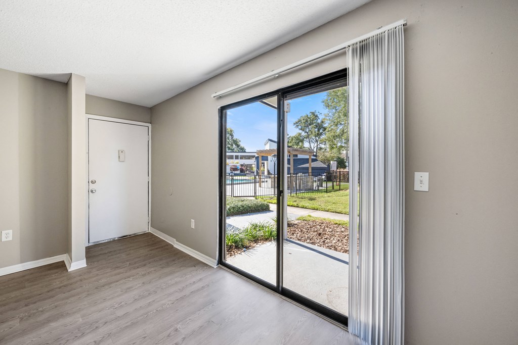 an empty living room with sliding glass doors to a yard