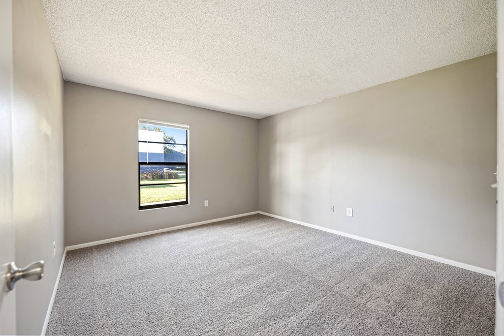 an empty room with carpet and a window