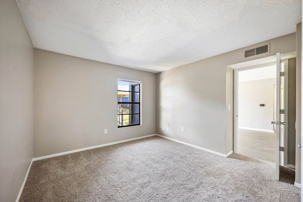 an empty living room with a door to a hallway