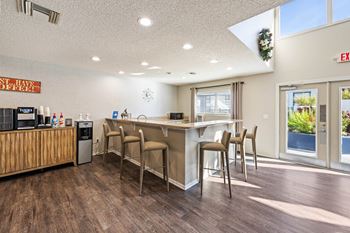 a kitchen with a bar and chairs in front of a window