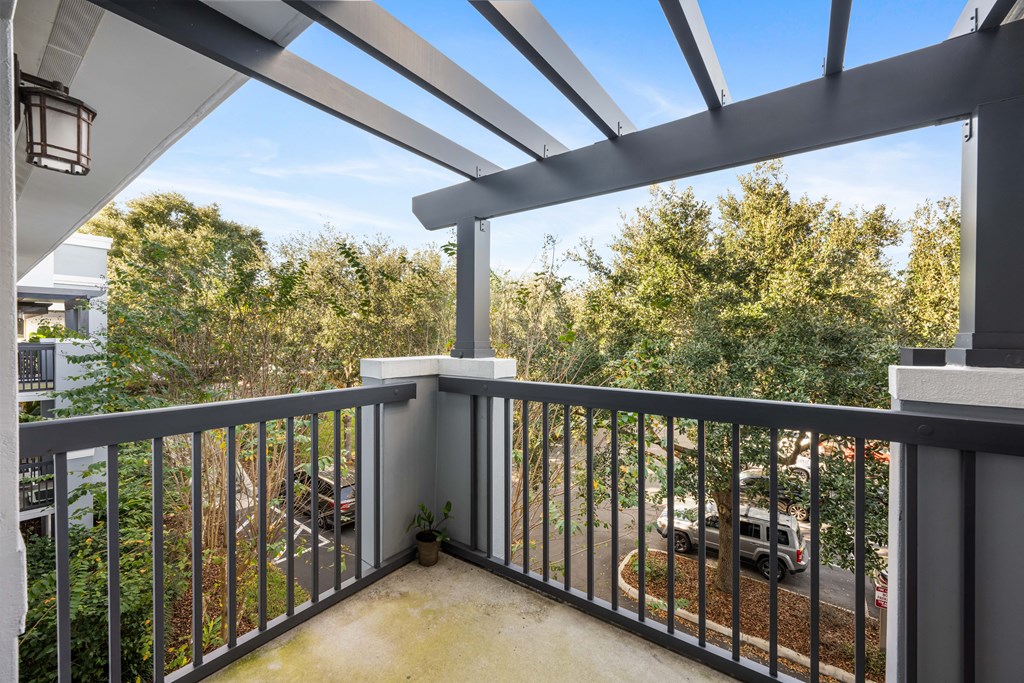 a balcony with a view of a parking lot and trees