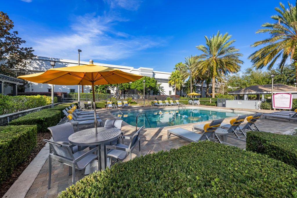a swimming pool with tables and umbrellas
