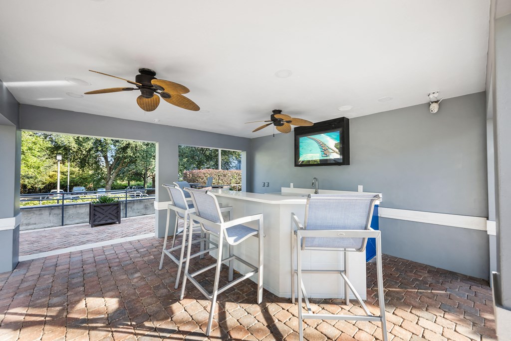 a dining area with a table and chairs and two ceiling fans