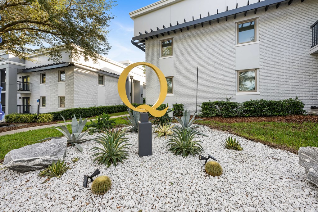 a yard with a large yellow sculpture in front of a building