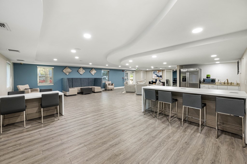 a communal area with tables and chairs and a bar in a lobby