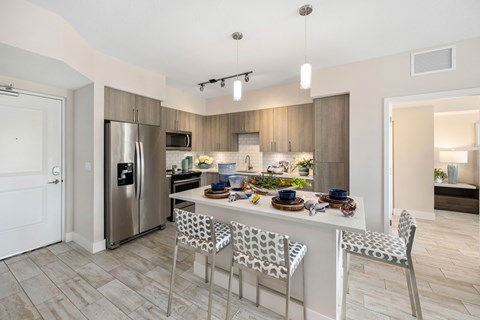 A modern kitchen with a dining table set for four.