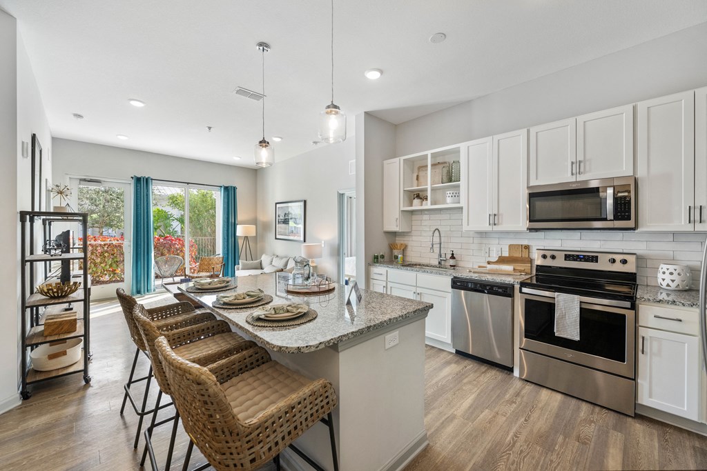 a kitchen with stainless steel appliances and a table with chairs