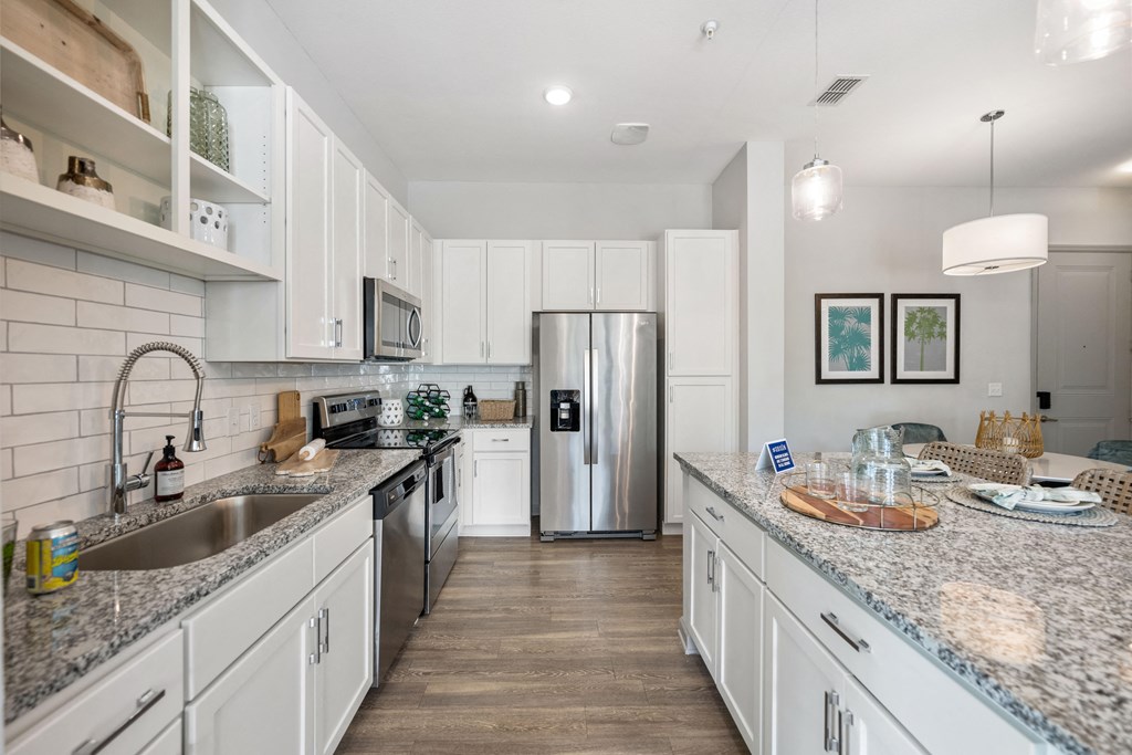 a large kitchen with granite counter tops and stainless steel appliances
