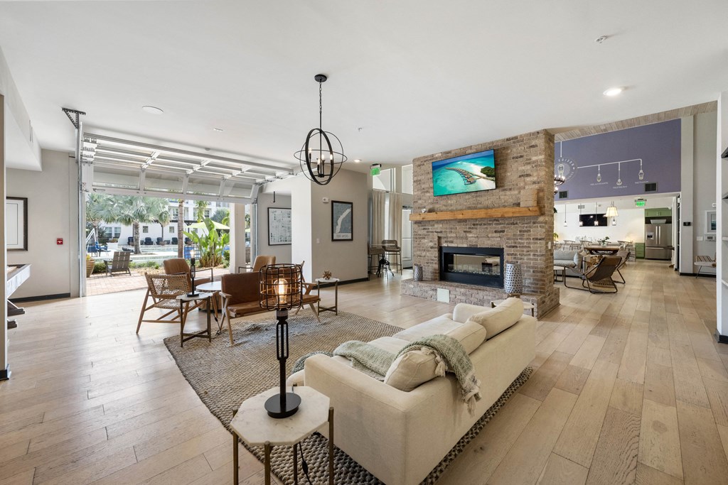 the living room has a large stone fireplace and hardwood floors