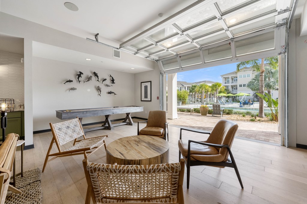 a living room with a ping pong table and chairs
