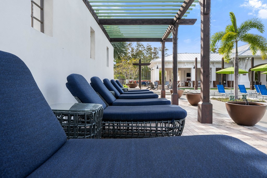an outdoor lounge area with blue couches and tables