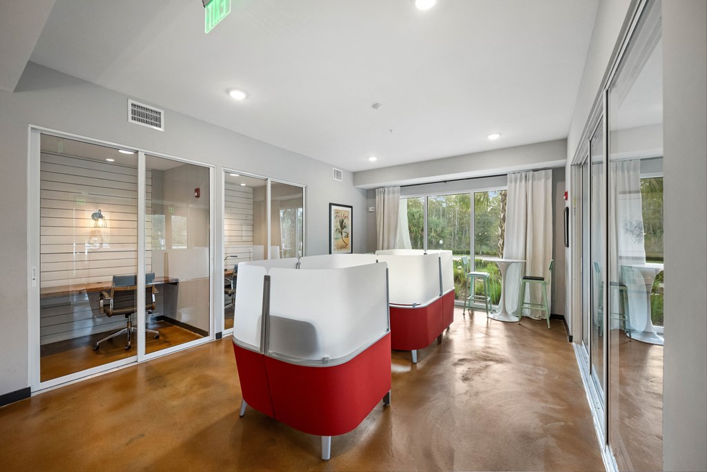 a living room with red and white furniture and glass doors
