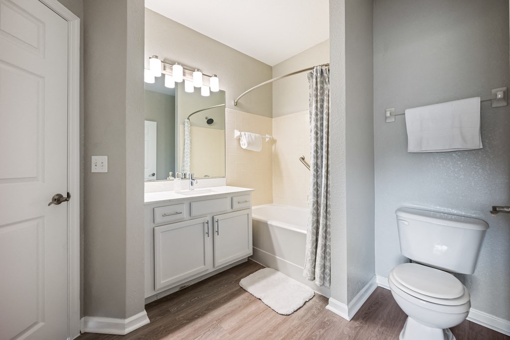 a bathroom with a toilet sink and shower and a mirror