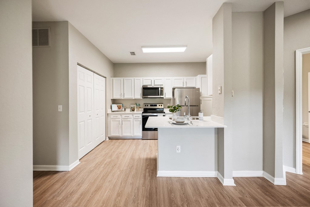 a spacious kitchen with white cabinets and a white counter top
