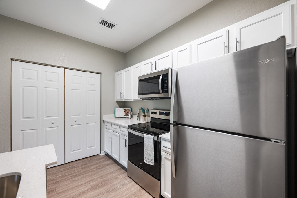 a kitchen with stainless steel appliances and white cabinets