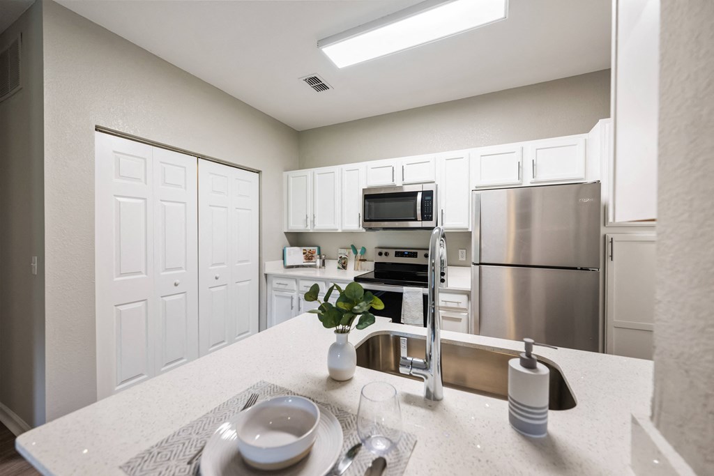 a kitchen with stainless steel appliances and white cabinets