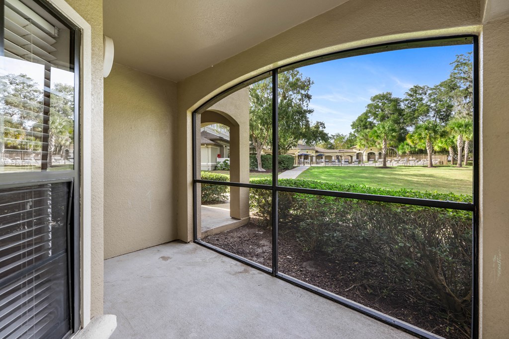 a patio with a large window and a view of a yard