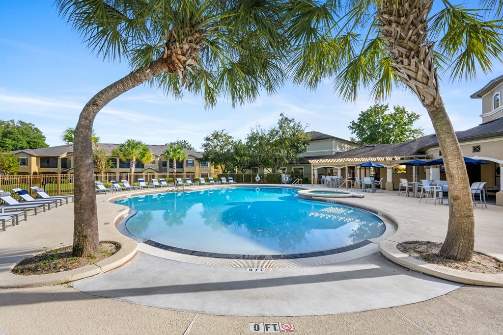 the resort style pool is surrounded by palm trees
