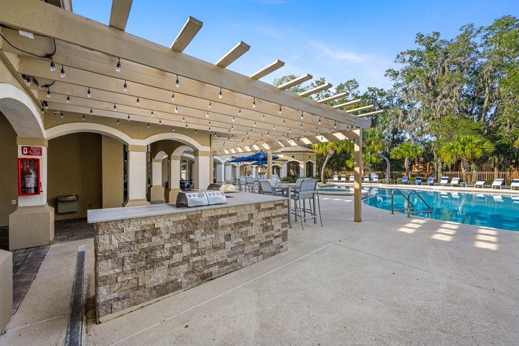the pool area has a bar and a swimming pool with tables and chairs
