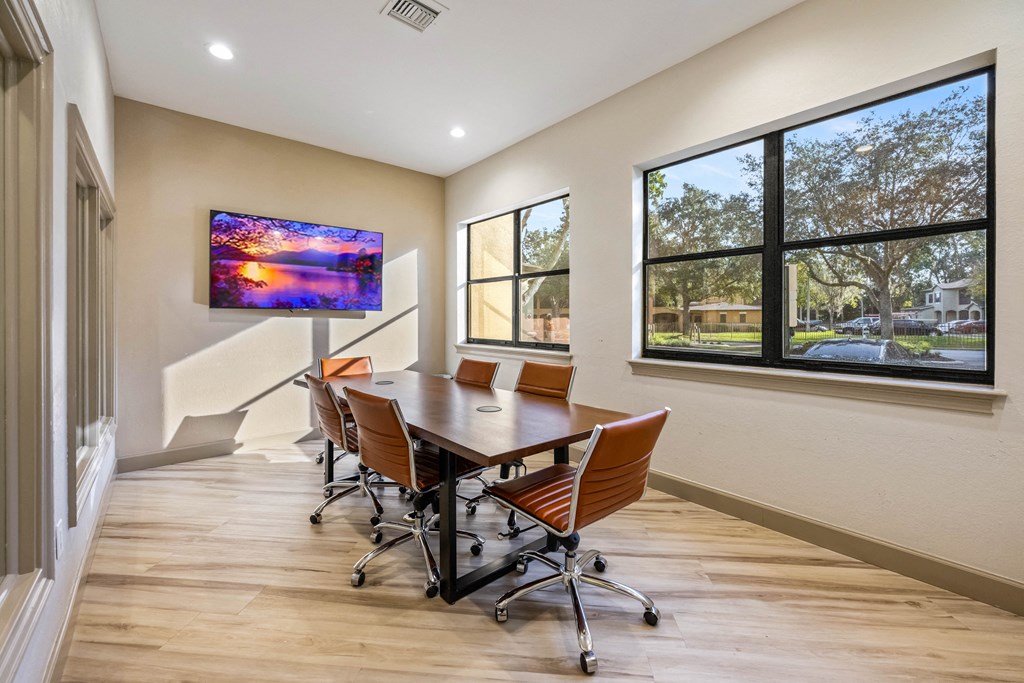 a conference room with a table and chairs and a large window