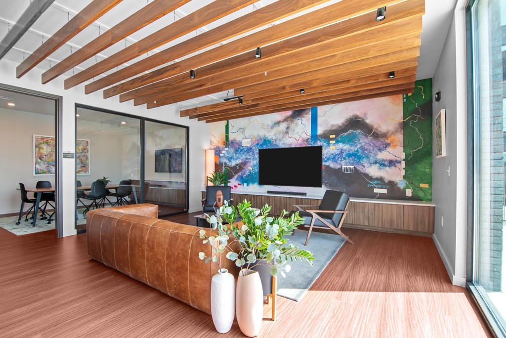 a living room with wooden floors and a large painting on the wall