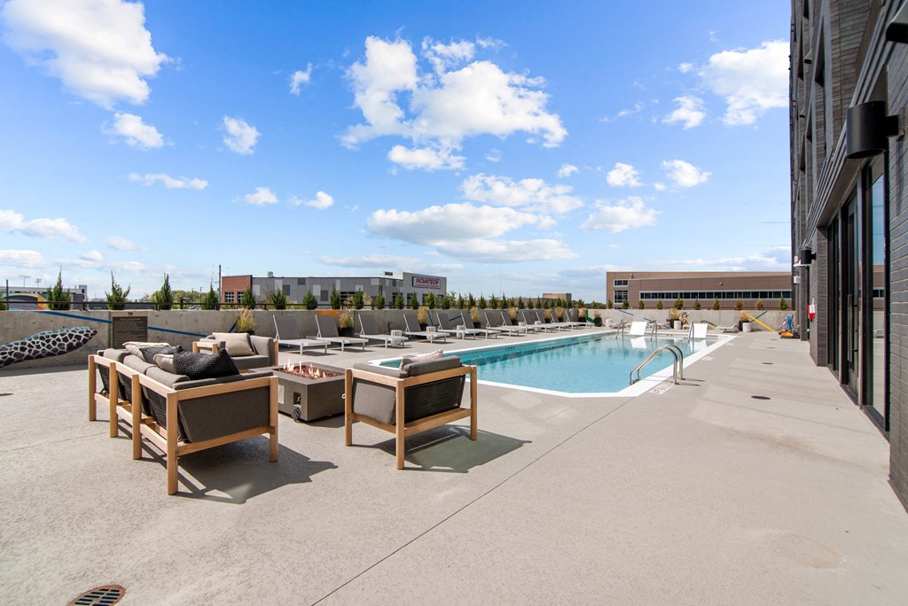 a swimming pool in the middle of a building with chairs and tables