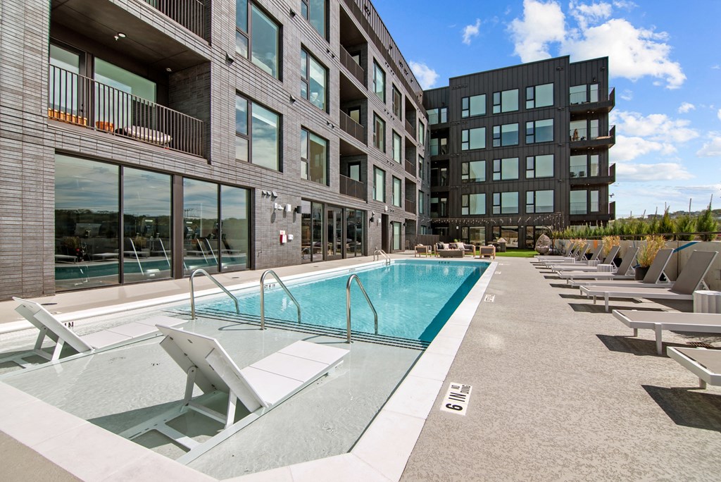 a swimming pool in the middle of two modern apartment buildings